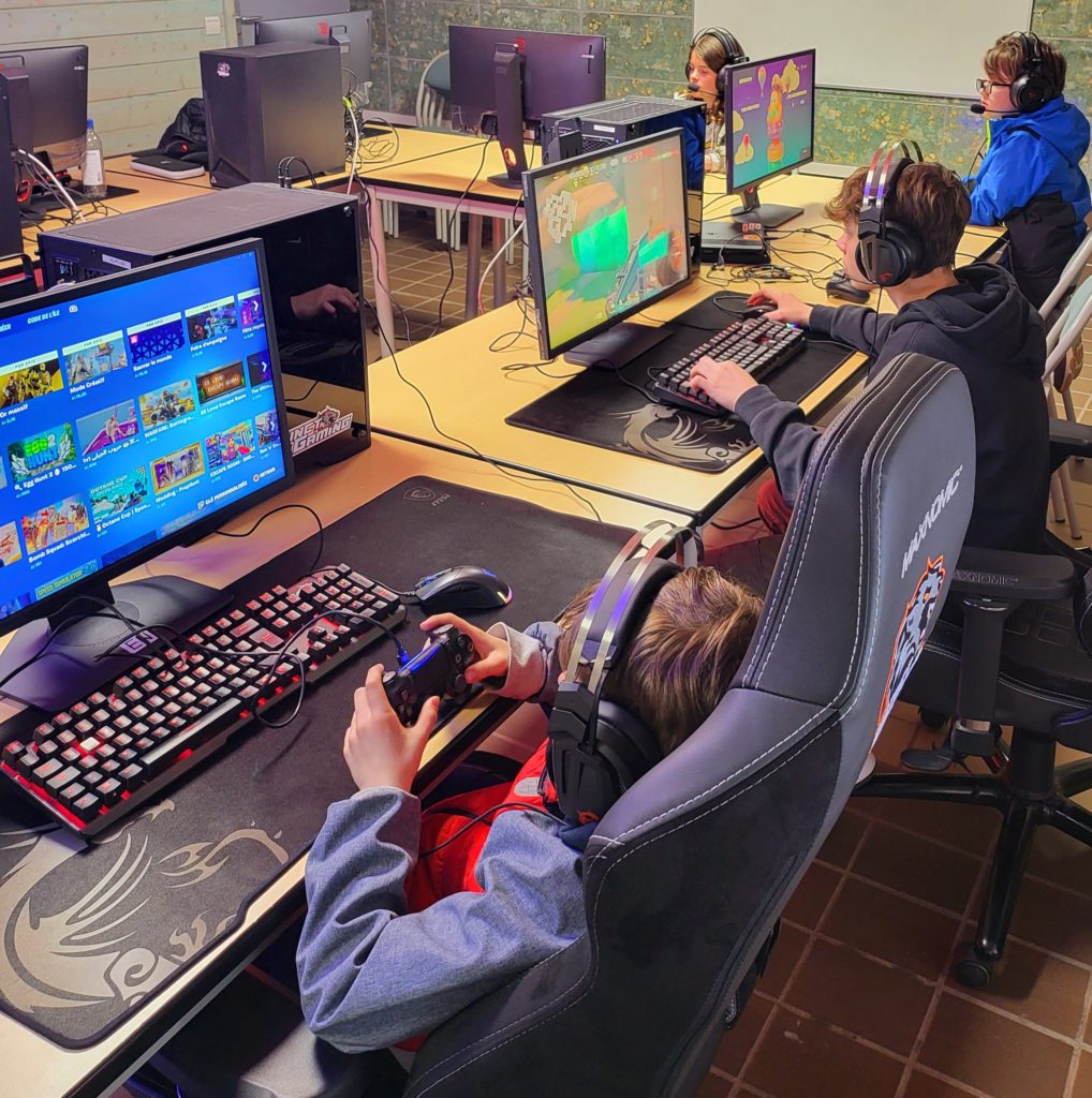 Plusieurs enfants jouent a une animation Fortnite sur ordinateur